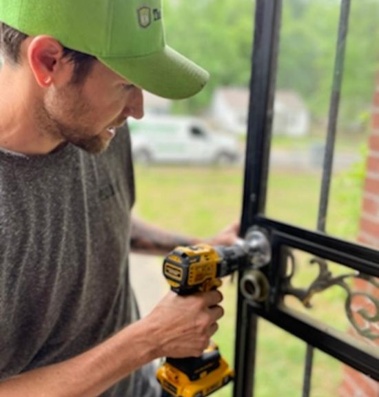 The Lockman employee fixing a lock on a door.